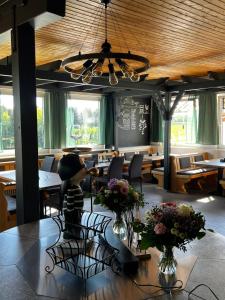 a dining room with tables and chairs and a table with flowers at Knaus Campingpark Lackenhäuser in Neureichenau