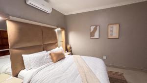 a bedroom with a large bed with a large headboard at Saob Property in Germiston