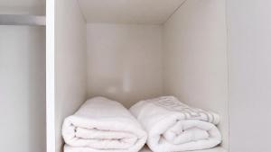 two white towels in a white closet at Saob Property in Germiston +27 photos