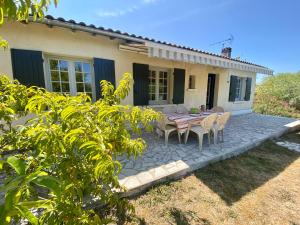 a patio with a table and chairs in front of a house at La Rousselie in Montagrier