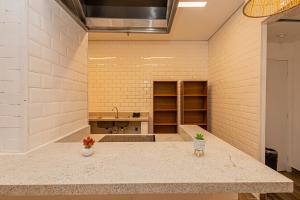 a large room with two vases on a counter at One House by Anora Spaces in São Paulo +55 photos