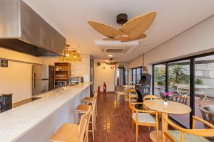 a restaurant with a bar with tables and chairs at One House by Anora Spaces in São Paulo