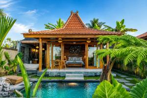 a villa with a pool and a house at Kubu Tama Villa in Tegalalang