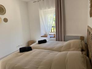 a bedroom with two beds and a window at Gîte du Trefoux logement Le Perche in Villaines-la-Gonais