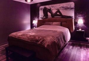 a bedroom with a bed with a person laying on it at La Suite Privée - Maison Privative Spa & Sauna in Évreux +17 photos
