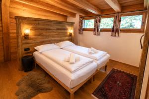 a bedroom with a bed with two towels on it at Chalet degli Abeti by AMA Val di Fassa in Campitello di Fassa