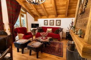 a living room with a red couch and a table at Chalet degli Abeti by AMA Val di Fassa in Campitello di Fassa