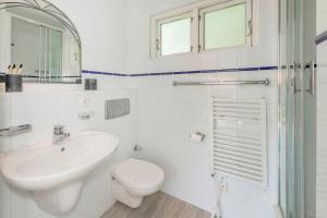 a white bathroom with a sink and a toilet at Ferienanlage Bansin Seepferdchen 5 in Bansin +23 photos