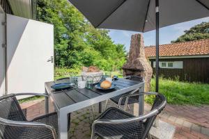 a table and chairs with an umbrella on a patio at Ferienanlage Bansin Seepferdchen 8 in Bansin