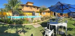 a house with a pool and a table and an umbrella at Kundalini Buzios in Búzios