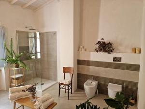 a bathroom with a shower and a toilet and a chair at Casa S'urtzula in Sini