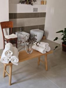 a bathroom with towels and a table with two toilets at Casa S'urtzula in Sini