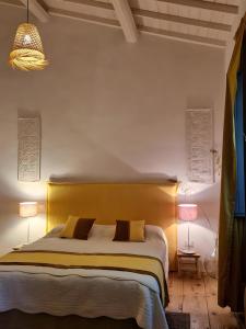a bedroom with a large bed with a yellow headboard at Casa S'urtzula in Sini
