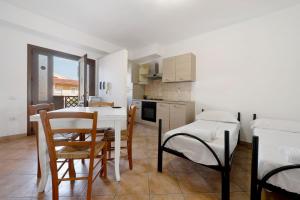 a kitchen and dining room with a table and chairs at Daluef Alloggi in Assemini