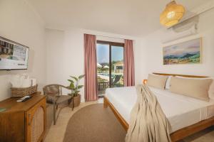 a bedroom with a bed and a desk and a window at Kiraz Vela Selimiye in Marmaris