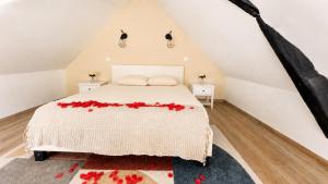 a bedroom with a bed with red flowers on it at COCON Mayennais - Loft Balnéo Laval in Laval