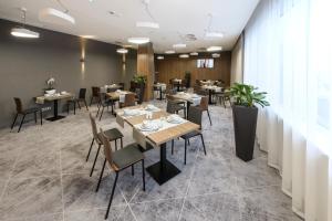 a restaurant with tables and chairs in a room at Hotel Centrum in Bolesławiec