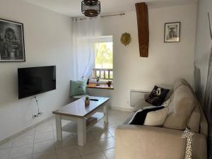 a living room with a couch and a table at Gîte du Trefoux logement Le Perche in Villaines-la-Gonais
