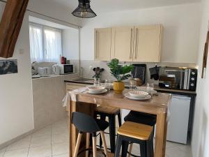 a kitchen with a wooden island with stools in it at Gîte du Trefoux logement Le Perche in Villaines-la-Gonais