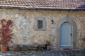 een stenen gebouw met een blauwe deur en een raam bij Agriturismo B&B Luna di Quarazzana in Fivizzano Tuscany in Fivizzano
