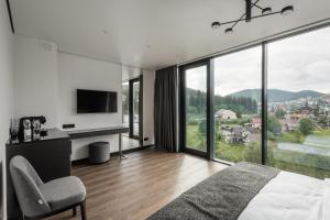 a bedroom with a bed and a large window at ETERNA HOTEL & SPA by Fomich in Palyanytsya