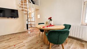 a dining room with a table and green chairs at COCON Mayennais - Loft Balnéo Laval in Laval