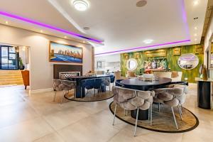 a dining room with two tables and stools at Braham Lodge - The Octave in Johannesburg