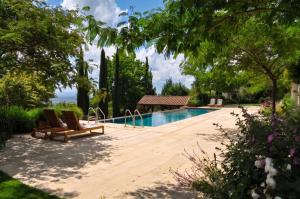 a backyard with a swimming pool and two lounge chairs at Lalisea in Talaveruela