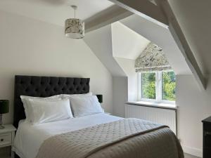 ein Schlafzimmer mit einem großen Bett und einem Fenster in der Unterkunft French Mill in Shaftesbury