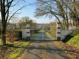 a gate to a driveway in front of a road at Gîte du Trefoux logement Le Perche in Villaines-la-Gonais +11 photos