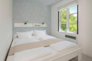 a bedroom with a bed with white sheets and a window at Ferienanlage Bansin Seepferdchen 1 in Bansin