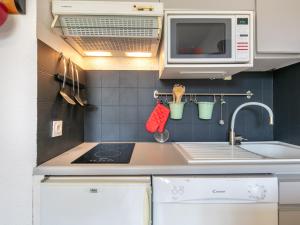 a small kitchen with a sink and a microwave at Le Belvedere N11 - ST4 in Saint-Sorlin-dʼArves