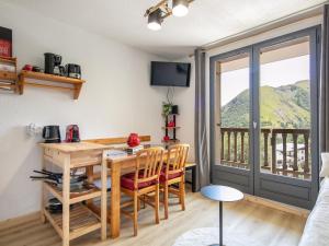 a living room with a table and chairs and a balcony at Le Belvedere N11 - ST4 in Saint-Sorlin-dʼArves