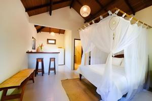 a bedroom with a bed with a canopy at Licuri Praia de Algodões na beira do mar in Marau