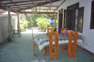 a table and chairs in a patio with a table and chairsktop at Talalla Mango House in Talalla South