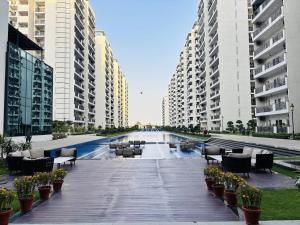 a boardwalk with chairs and tables and buildings at Romantic Sky Studio with Pool by The Nook in Sohna