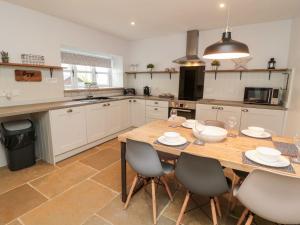 a large kitchen with a wooden table and chairs at Canny Cottage in Belford