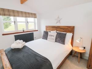 a bedroom with a large bed with a wooden headboard at Canny Cottage in Belford