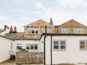 a detached house with a white facade at Canny Cottage in Belford
