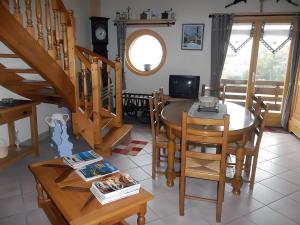 a dining room with a table and chairs and a television at Gite Le Chant Du Coq in Bief-des-Maisons