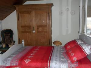 a bedroom with a bed with a red blanket at Gite Le Chant Du Coq in Bief-des-Maisons