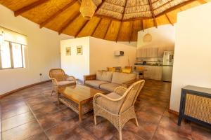 a living room with a couch and a table and chairs at Cabañas Refugio El Molle in El Molle