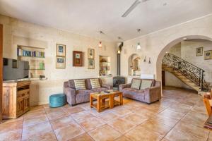 a living room with two couches and a staircase at Ta' Gianni in Xewkija