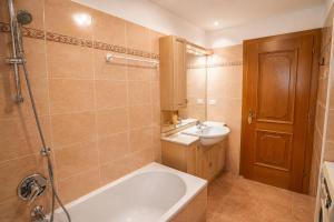a bathroom with a tub and a sink and a toilet at Casa Cesarina by AMA Val di Fassa in Canazei +10 photos