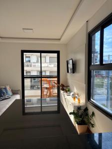 a living room with a view of a balcony at Apê Ásia in Governador Celso Ramos