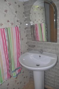 a bathroom with a white sink and a mirror at Talalla Mango House in Talalla South