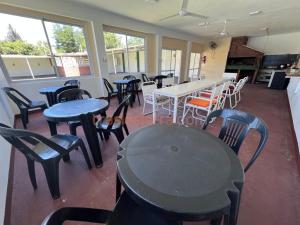 a dining room with tables and chairs and windows at Mi Petaka in Villa Cura Brochero