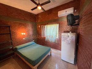 a room with a bed and a refrigerator in it at Mi Petaka in Villa Cura Brochero