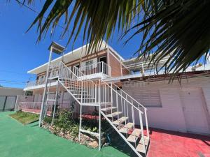 a house with a spiral staircase in front of it at Mi Petaka in Villa Cura Brochero