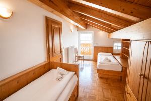 a bedroom with two beds in a room with wooden ceilings at Casa Cesarina by AMA Val di Fassa in Canazei